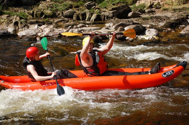 Personnes portant des équipements rouges et jaunes en kayak